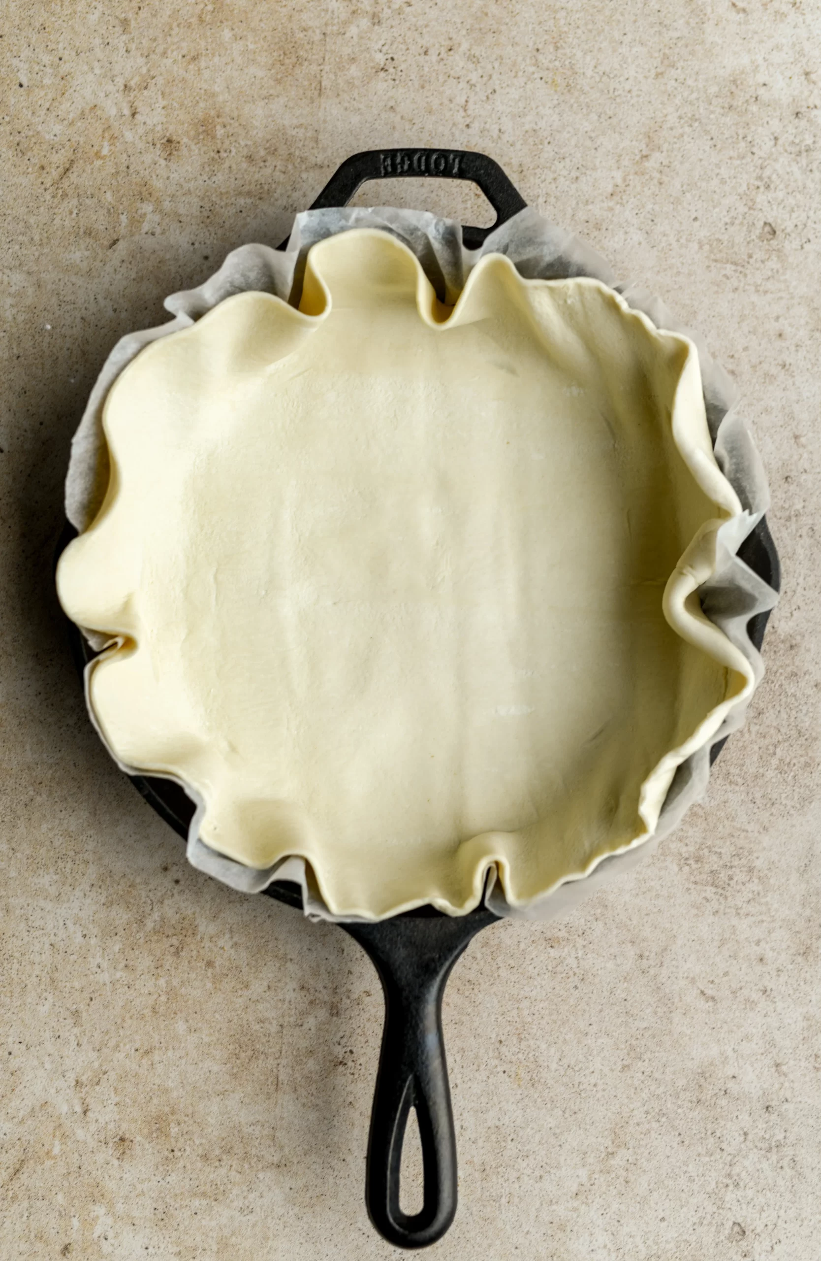 cast iron pan lined with parchment paper and puff pasty