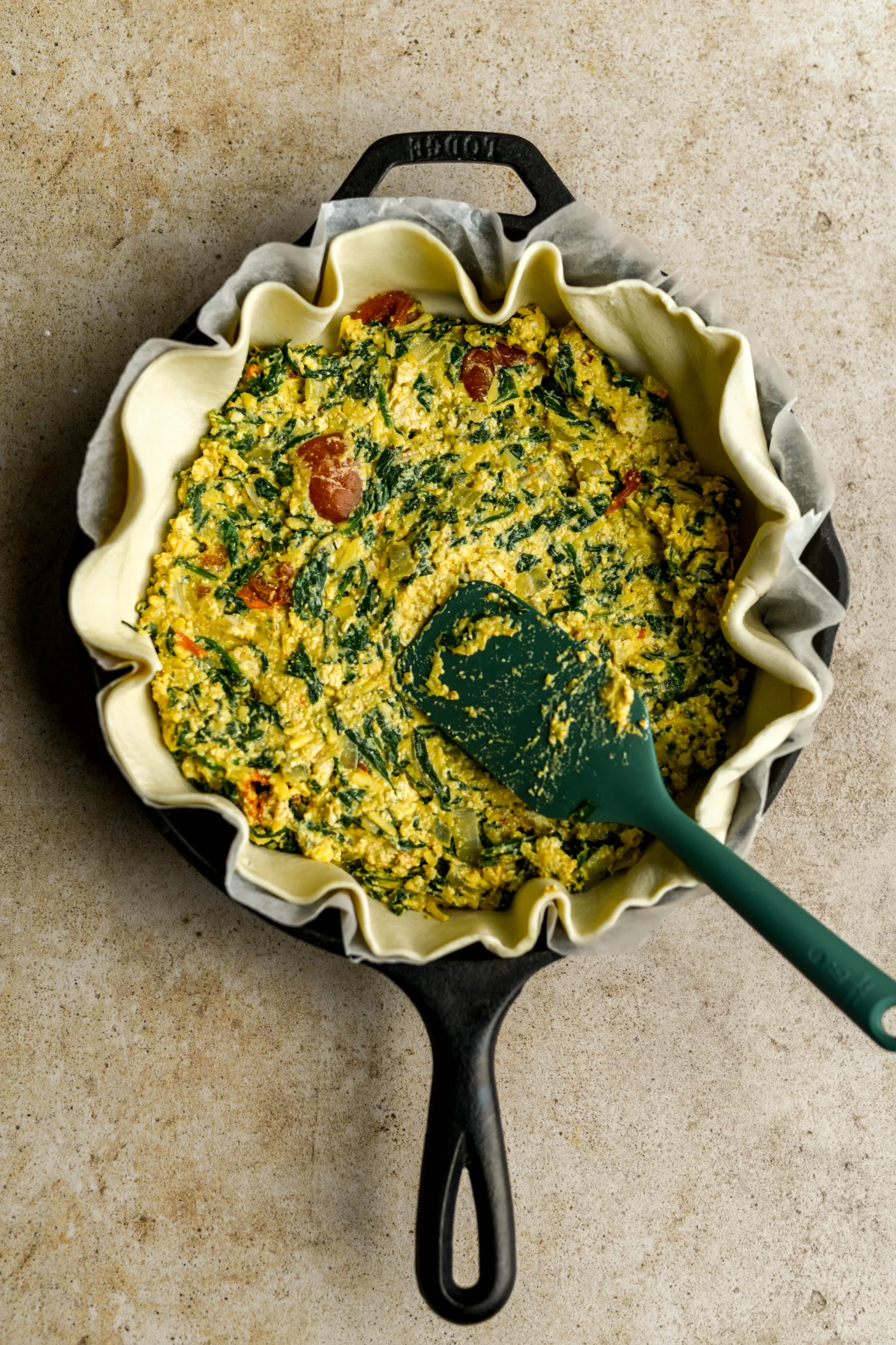 spinach pie filling added to pan with spatula