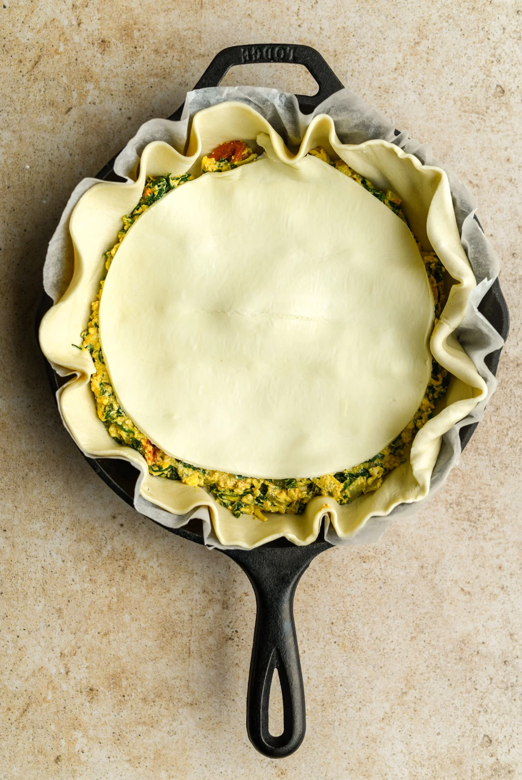 spinach pie filling added to pan topped with puff pastry