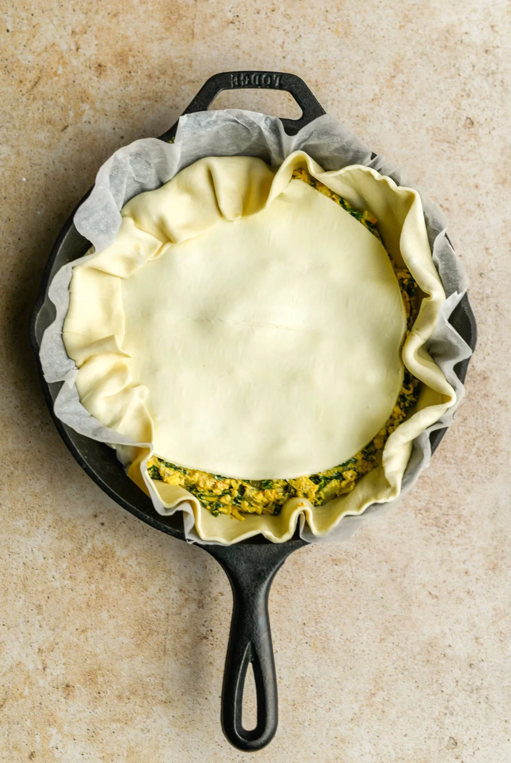spinach pie filling added to pan topped with puff pastry